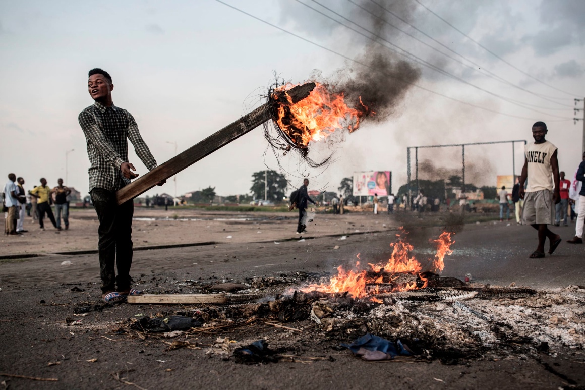 n partisan de Martin Fayulu, finaliste aux élections en République démocratique du Congo (RDC), brandit une planche de bois en feu alors qu'il manifestait dans la rue le 21 janvier 2019 à Kinshasa, contre la décision de Félix Tshisekedi en tant que président de la RDC.