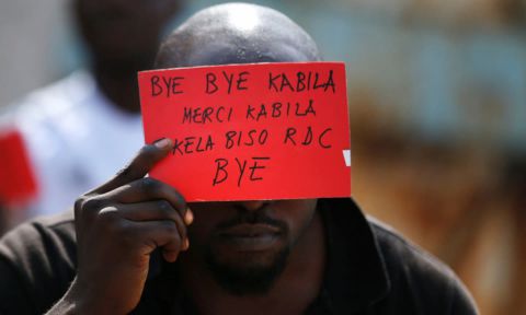 Un homme tient une pancarte avec un message pour le président Kabila lors de manifestations à Kinshasa lundi. Photographie : Thomas Mukoya /Reuters