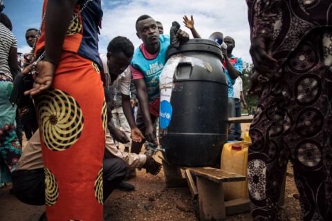 Plusieurs personnes font la queue pour se laver les mains à l'eau chlorée destinée à prévenir la propagation du virus Ebola dans un bureau de vote emblématique de Beni, en République démocratique du Congo, le 30 décembre 2018.