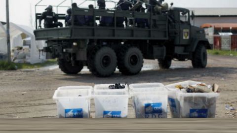 Des militaires passent près d'urnes électorales transformées en poubelles, après les élections de décembre 2011. © Jerome Delay/AP/SIPA
